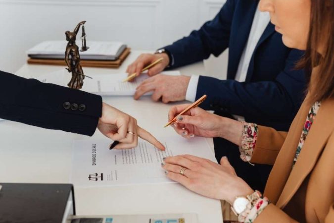 Un avocat montrant un document de divorce et une prestation compensatoire à des clients.